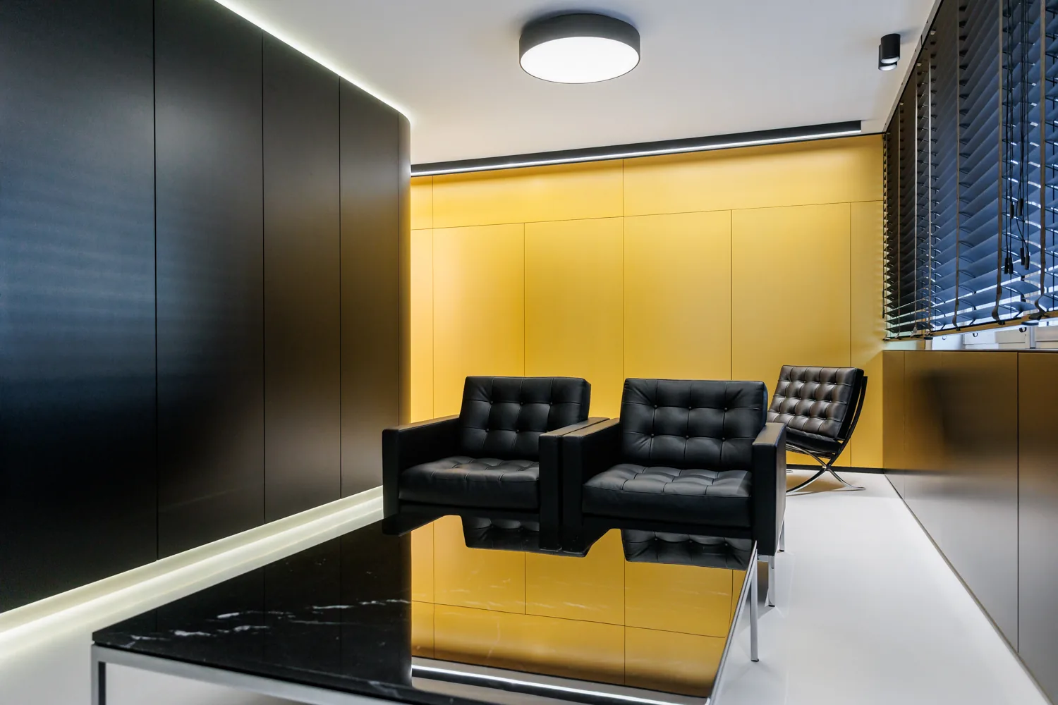 Behandlungs- und Wartebereich der Praxis B-Kö Smiles in Düsseldorf — Schwarz-Gold-Interieur mit Designer-Ledersesseln