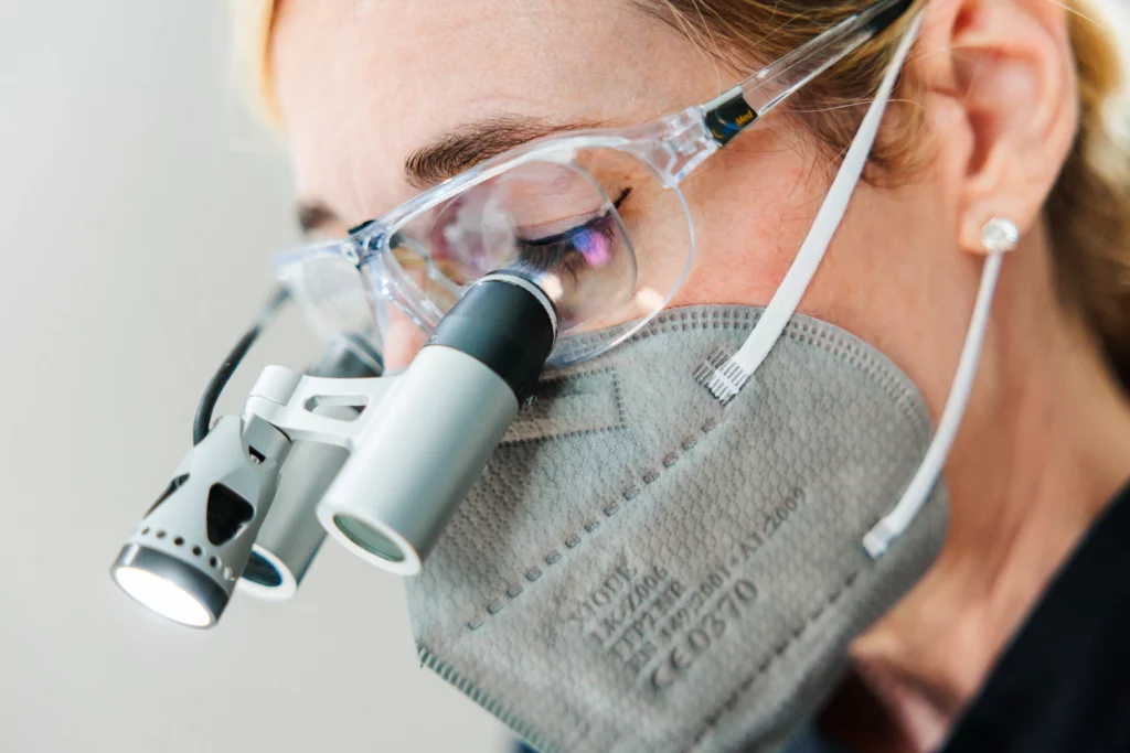 Zahnärztin mit dentaler Lupenbrille bei der Präzisionsarbeit – B-Kö Smiles, Schadowstraße Düsseldorf